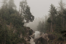 rugged waterfall in misty forest