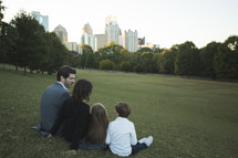 a family sitting in grass at a park 