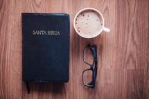 Santa Biblia, reading glasses, and cappuccino 