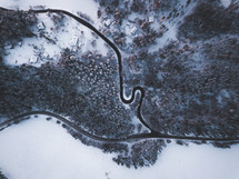 aerial view over a curvy road and snow 