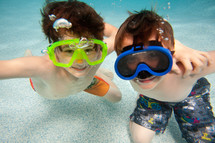 boys wearing goggles under the water 