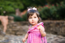 a toddler girl in a pink dress