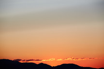 silhouettes of hills and a red sky at sunset 