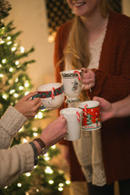 Four women put their Christmas cups together in a toast.