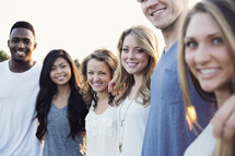 smiling faces of a group of young adults 
