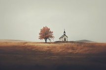 A small church in the middle of a field with a lonely tree