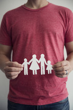man holding a paper cutout of a family 