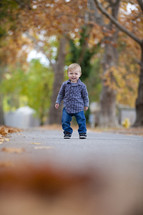 Toddler standing on sidewalk smiling
