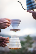 pouring and filtering coffee outdoors 