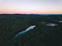 aerial view over a pond in a forest 