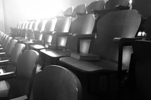 rows of seats in a theater with hymnals 