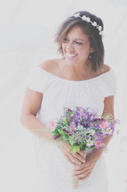a smiling bride holding a bouquet of flowers 