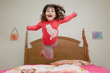 child jumping on a bed 