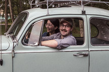 a couple riding in a vintage Volkswagen Beetle 