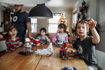 kids eating cookies around a table at Christmas 