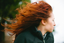 woman with red curly hair blowing in the wind