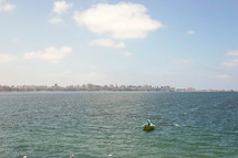 man rowing a boat and view of a city along a shoreline in Egypt 
