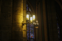 candelabras, chandeliers, and stained glass windows in a cathedral 