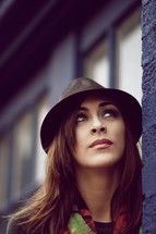 A college-aged woman with brown hair looking up - pondering, thinking 