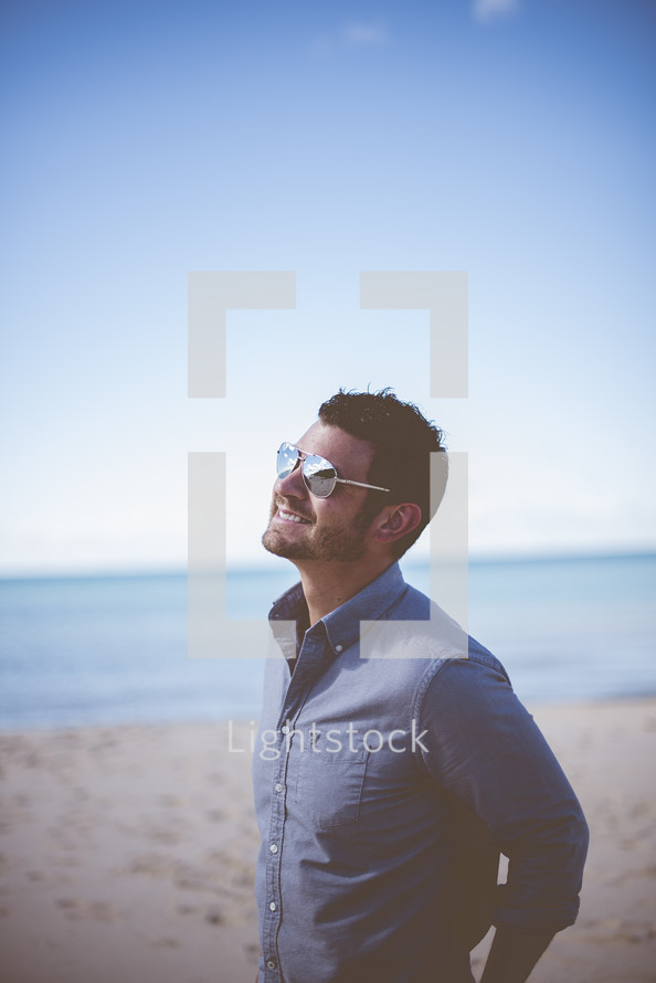 man smiling standing on a beach 