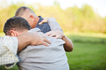men praying together outdoors 
