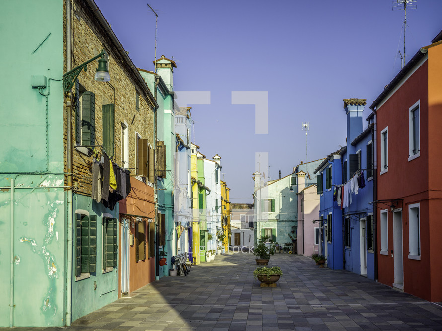 Brightly colored homes on street with pavers
