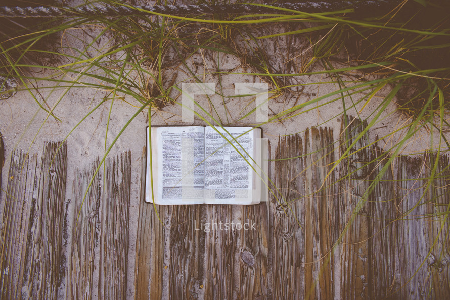 open Bible on a beach boardwalk 