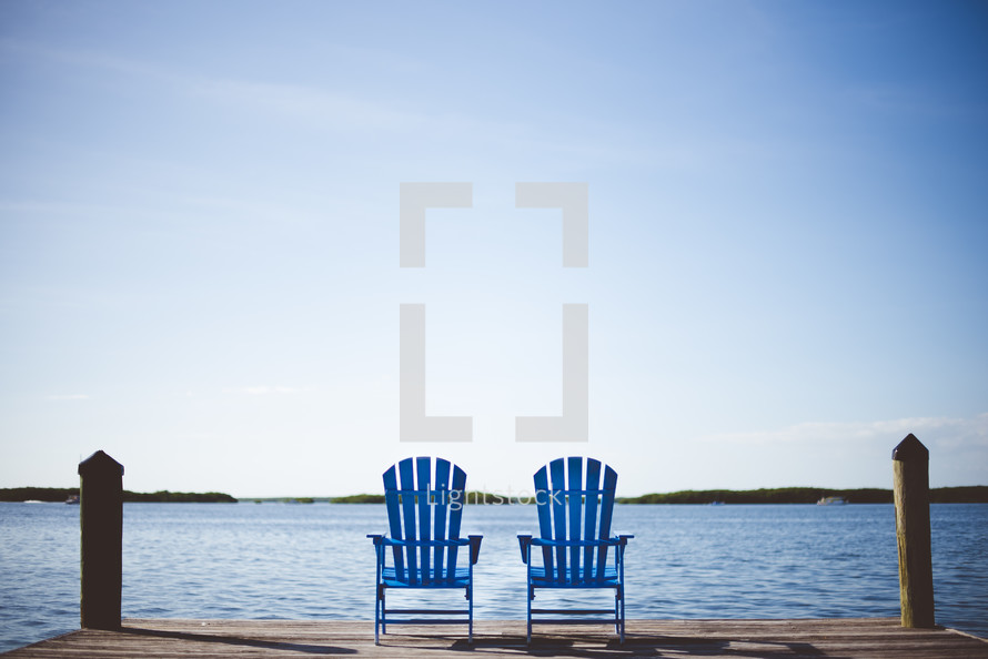 adirondack chairs on a dock 
