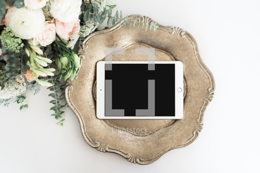 iPad on a silver tray and bouquet of flowers 