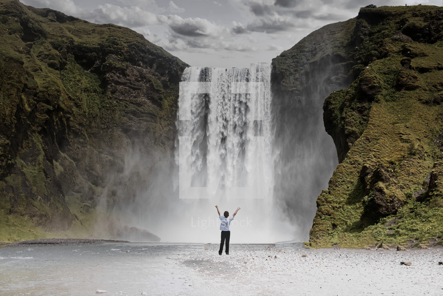 a person standing in front of a waterfall with hands raised 