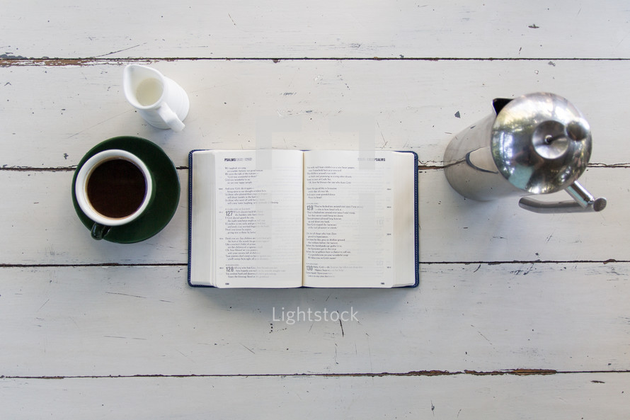 open Bible on a wood floor and coffee cup 