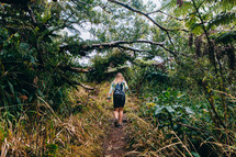a woman hiking through a jungle 