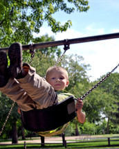Young boy on a swing in the park.
