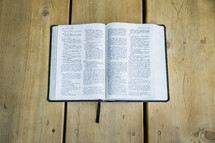 open Bible on a wood floor 