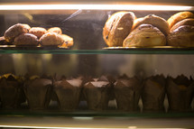muffins and pastries in a display case 
