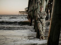 portrait of a soldier under a pier at a beach 