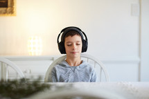 boy listening to headphones and relaxing at home with eyes closed