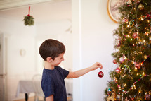 child decorating a Christmas tree 