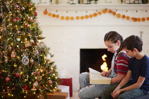 children reading a Bible around a Christmas tree 
