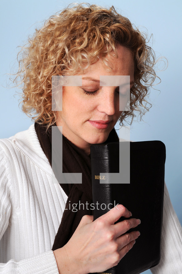 woman praying holding a Bible 