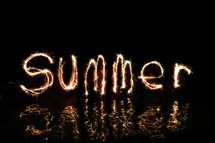 The word 'Summer' written in fireworks  (by five 'artists' standing in waist high water - The middle 'Artist' wrote both letter m's.)