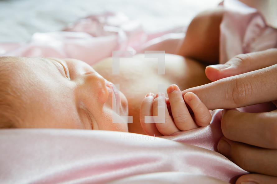 newborn holding on to mom's finger 