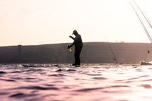 a fisherman standing on the edge of a shore 