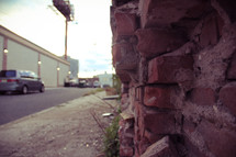a broken brick wall and sidewalk 
