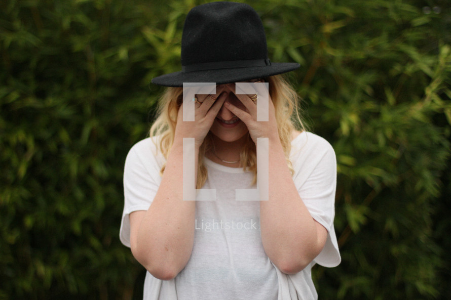 a woman hiding her face 