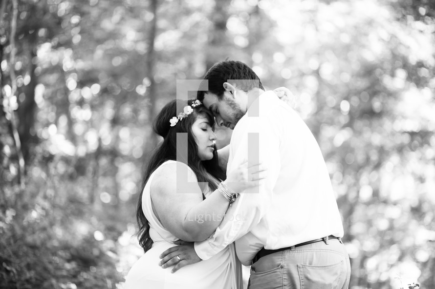 bride and groom embracing in the woods 