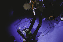 guitarist and foot pedals on stage 