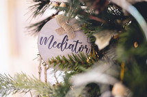 Wooden ornament with the word "mediator" on a Christmas tree 