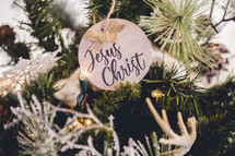 Wooden ornament with the word "Jesus Christ" on a Christmas tree 