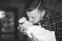 father with a swaddled newborn baby girl 